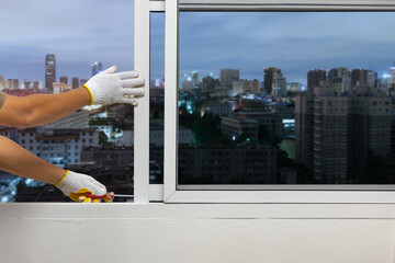 Construction worker repairing the sliding window on condominium room.