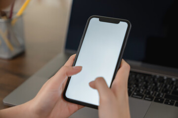 Hand holding smartphone mockup of blank screen for graphic display montage.