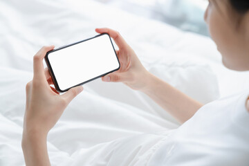 Hand holding smartphone mockup of blank screen for graphic display montage.