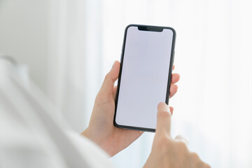 Hand holding smartphone mockup of blank screen for graphic display montage.