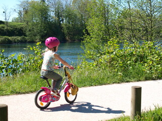 Petite fille &agrave; v&eacute;lo au bord de la rivi&egrave;re