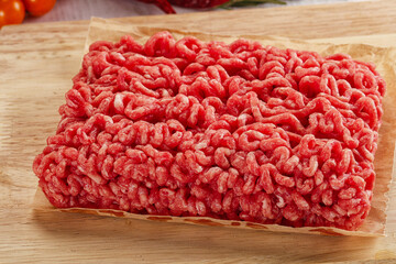 Raw minced beef meat over board
