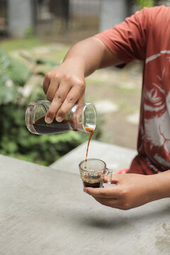 someone is pouring v50 coffee into a glass to drink