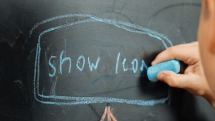 Closeup of smart student or boy hand writing prompt on blackboard. Child planing project and...