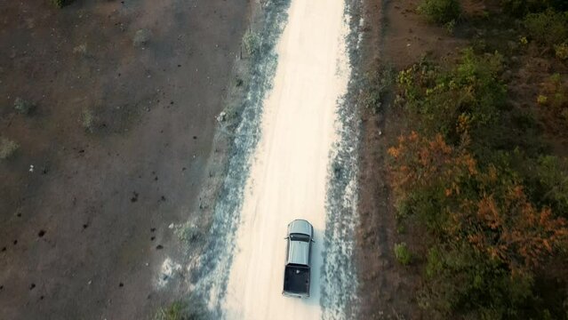 vehiculo seguido por drone por terraceria camino o brecha en el bosque dentro de la jungla paisaje arbolado camioneta off road todo terreno troca pasando por la terraceria en Corozal belice