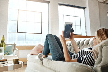 Young woman, tablet or happy with search in home on sofa, reading news or story on social media....