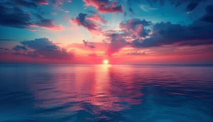 A beautiful sunset over the ocean with a pink and blue sky