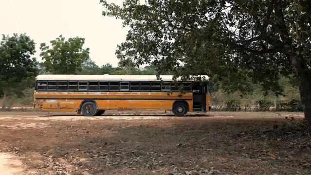 Bus escolar autobus de escuela rural en centroamerica Corozal Belice camion amariilo escolar estacionado afuera de un poblado en el camino