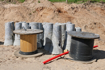 Reels with power electrical cable and concrete pillars on a construction site