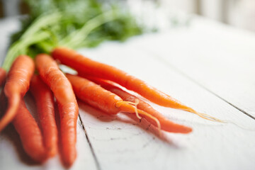 Food, carrots and nutrition for health with wellness, detox, lunch snack and lose weight with vegan or vegetarian diet. Closeup vegetables, raw and vitamin c benefits for digestion on wood table