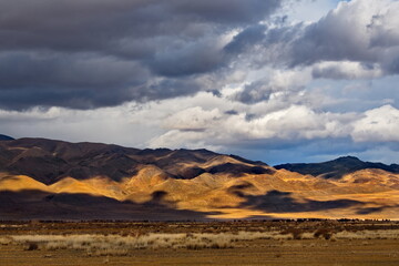 Russia. The South of Western Siberia, the Altai Mountains. Unusual contrasts partially illuminated by the setting sun relief mountains along the Chuya River valley near the village of Kash-Agach.