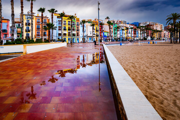 Reflections of the houses in the puddles on the beach promenade