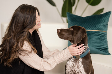 Women looking into eyes and touching german shorthaired pointer