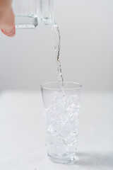 Close-up of a water being poured in a glass by a woman's hand