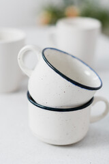 Close shot of white mugs pile in a white kitchen