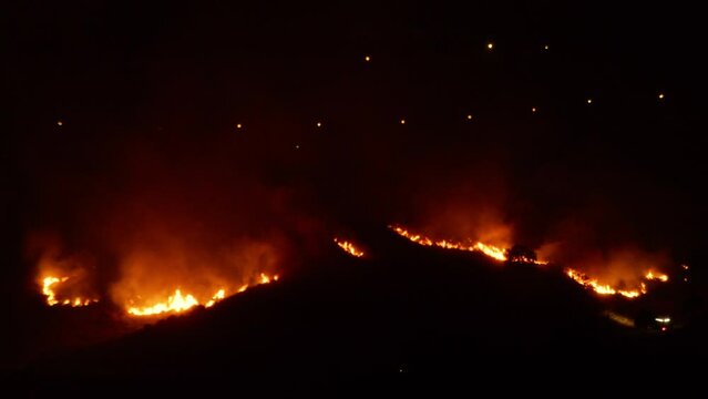 Wild fire devours hill in the night