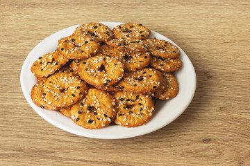 Salted round pretzels with black and white sesame on a plate