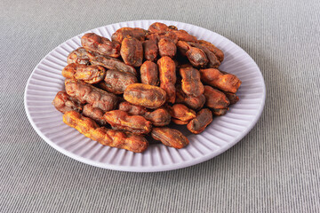 Sweet, spicy tamarind tree fruit in round plate on table tablecloth