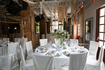 Wedding reception venue decorated with flowers and candles inside building