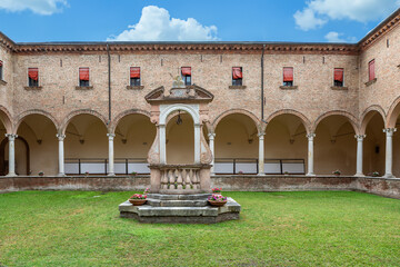 Ancient stone well displayed in tranquil italian courtyard of brick building
