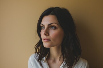 Obraz premium Portrait of a beautiful young brunette woman in a white shirt