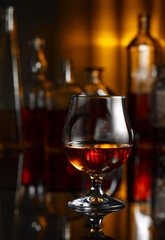  Snifter of brandy on a black table in bar.
