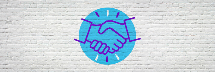Handshake on brick wall