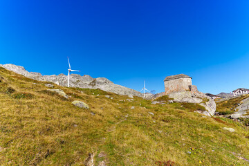 Scenic view of summit at Swiss mountain pass Gotthard with buildings and stone chapel on a sunny...
