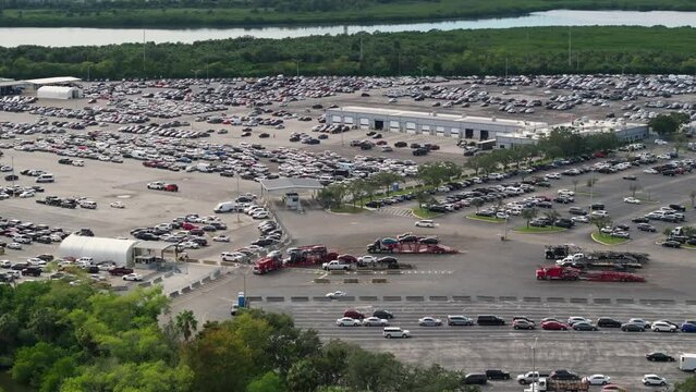 Used cars on car hauler semi truck tractors at dealer auction reseller company big parking lot ready for resale services. Sales of secondhand vehicles