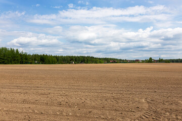 Preparing field for planting. Plowed soil  in springtime with blue sky.