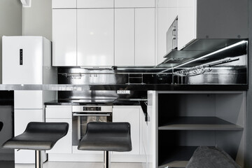 modern minimalistic black and white kitchen. Kitchen with built-in appliances, microwave, oven,...