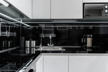 modern minimalist black and white kitchen.  Kitchen with built-in kitchen appliances, microwave,...