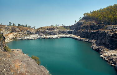 Fototapeta premium baghmundi purulia, west bengal tourism, marble lake water project, geographical landscape, igneous rock formation, rustic terrain, serene nature, deep blue green water, stone boulders, crater created 