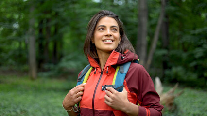 Young woman hiking in the forest and enjoying
