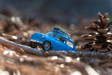 Miniature car adventuring through autumn forest