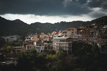 Fototapeta premium Dark storm clouds gathering over Agros village in Troodos mountain valley. Limassol District, Cyprus