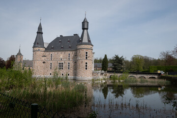Fototapeta premium Jehay Bodegnée Castle Château in Belgium Ardennes. historic fortified building popular tourist attraction on sunny summer day. fresh water moat surrounds rural landmark structure near Liège