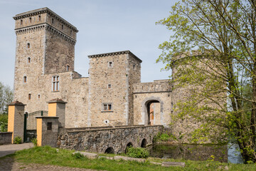 Obraz premium historic fortified building popular tourist attraction on sunny summer day. fresh water moat surrounds rural landmark structure near Liège