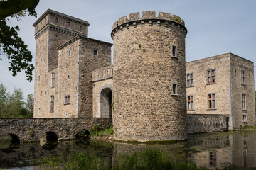 historic fortified building popular tourist attraction on sunny summer day. fresh water moat surrounds rural landmark structure near Li&egrave;ge
