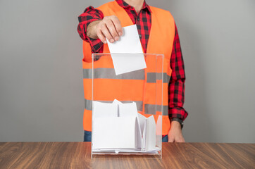 A voter casting a ballot into a ballot box on election day. Referendum, democracy,  plebiscite,...