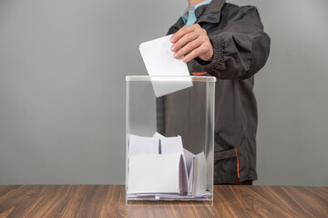 A voter casting a ballot into a ballot box on election day. Referendum, democracy,  plebiscite,...