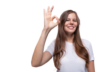 Young woman shows ok gesture and smiles sweetly