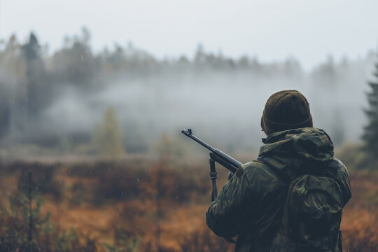 Hunter in the woods with a gun Man with a rifle in the woods Hunter aiming at a deer Man hunting in the forest Hunter in the woods