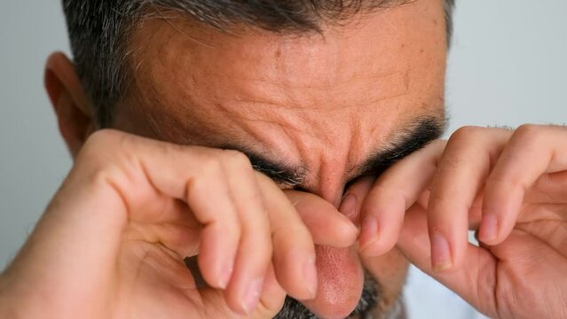 A mature man rubbing his eyes because he is sleepy or have allergies. Eyes irritation.