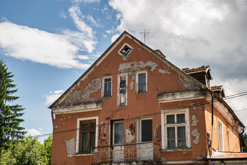 Old neglected and crumbling nice countryside town house on sunny day