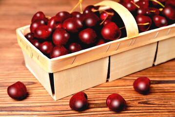 Ripe natural cherries, sweet cherries in a birch bark basket on a wooden background