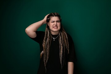 Woman With Dreadlocks Standing in Front of a Green Wall