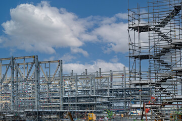 Construction site with cranes on orange sunset, sunrise sky background. Steel frame structure, structural steel beam build large buildings at construction site . construction machinery.