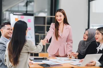 Professional businesswomen shaking hands during a team meeting, successful collaboration and agreement.