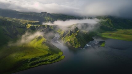 Obraz premium A stunning aerial view of misty mountains and lush green valleys wrapped in clouds, with a serene lake adding to the breathtaking landscape.